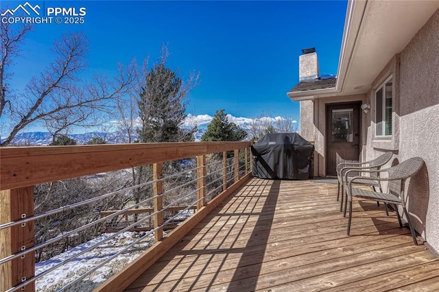 snow covered deck with a grill