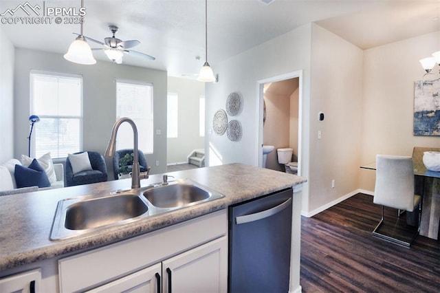 kitchen with stainless steel dishwasher, dark wood-type flooring, sink, white cabinets, and hanging light fixtures