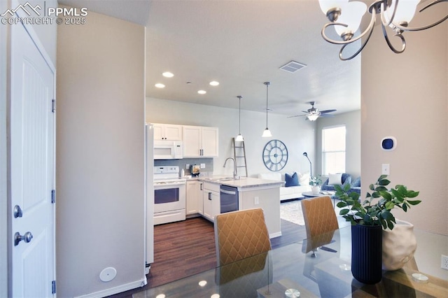 kitchen featuring sink, kitchen peninsula, decorative light fixtures, white appliances, and white cabinets