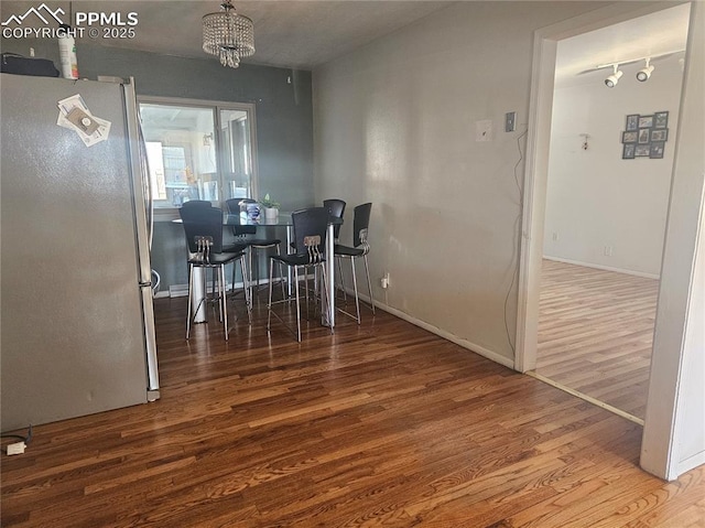 dining area featuring an inviting chandelier and hardwood / wood-style floors