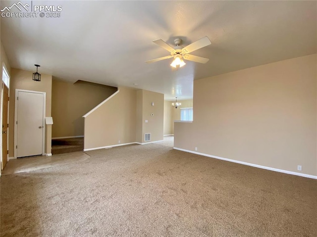 unfurnished living room featuring carpet flooring, ceiling fan with notable chandelier, and a wealth of natural light