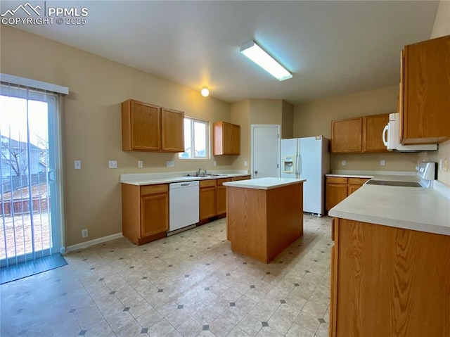 kitchen with white appliances, a kitchen island, and sink