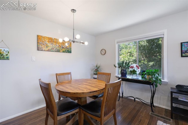 dining room with a notable chandelier and dark hardwood / wood-style flooring