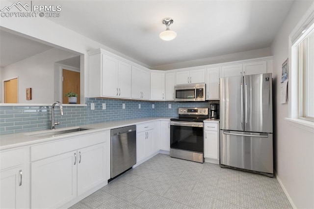 kitchen with decorative backsplash, sink, white cabinets, and stainless steel appliances