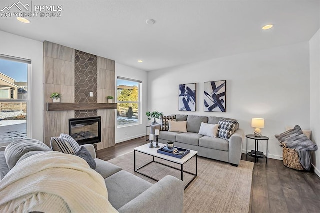 living room with a tiled fireplace and hardwood / wood-style floors