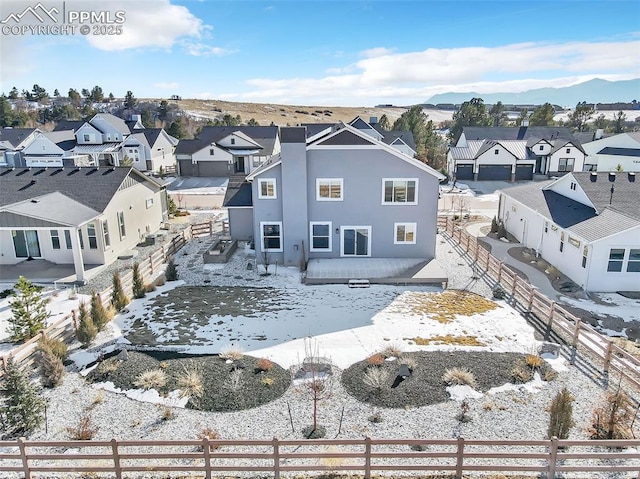 snow covered back of property featuring a mountain view