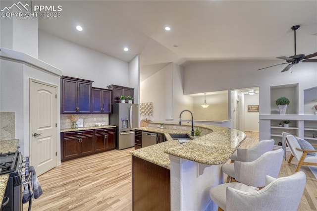 kitchen featuring light stone countertops, ceiling fan, backsplash, pendant lighting, and appliances with stainless steel finishes