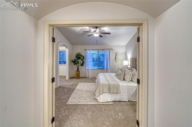 carpeted bedroom with ceiling fan and lofted ceiling