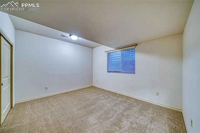 unfurnished room featuring light carpet