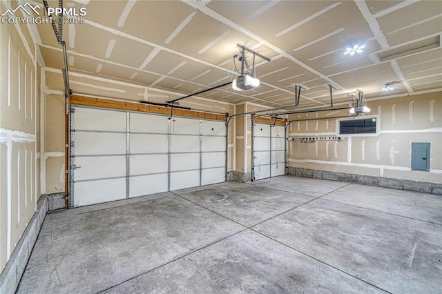 garage with a garage door opener and electric panel