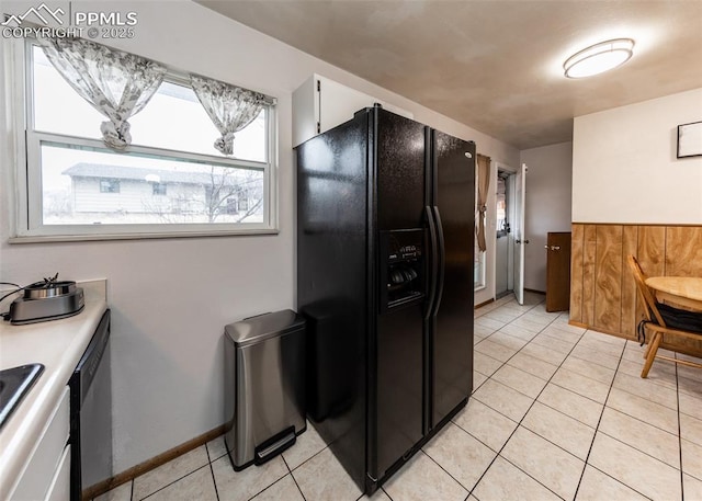 kitchen featuring white cabinets, black refrigerator with ice dispenser, dishwasher, and light tile patterned floors