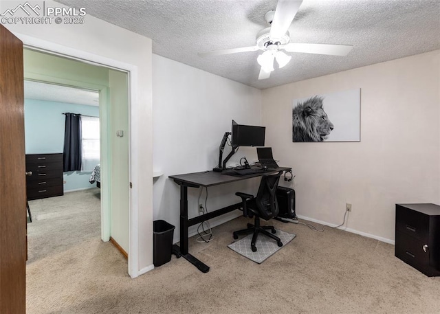 office with a textured ceiling, ceiling fan, and light carpet