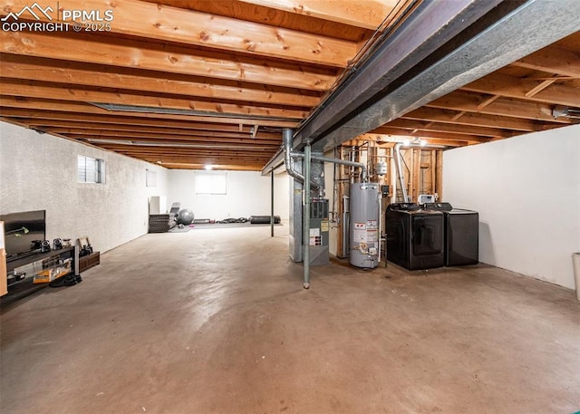 basement with heating unit, water heater, and washing machine and clothes dryer