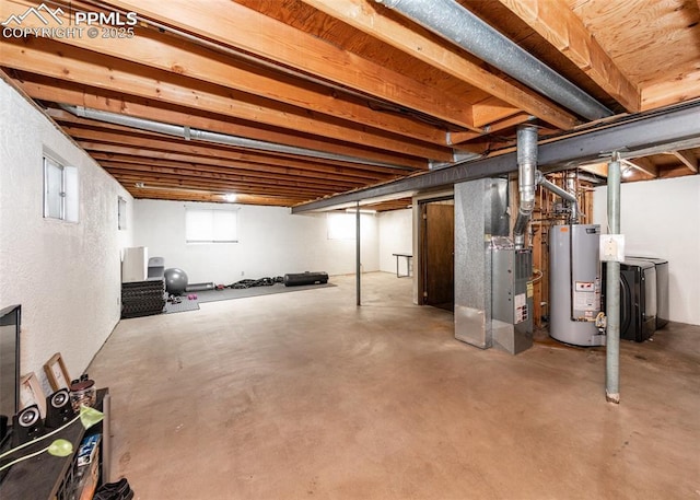 basement with heating unit, gas water heater, and washer / dryer