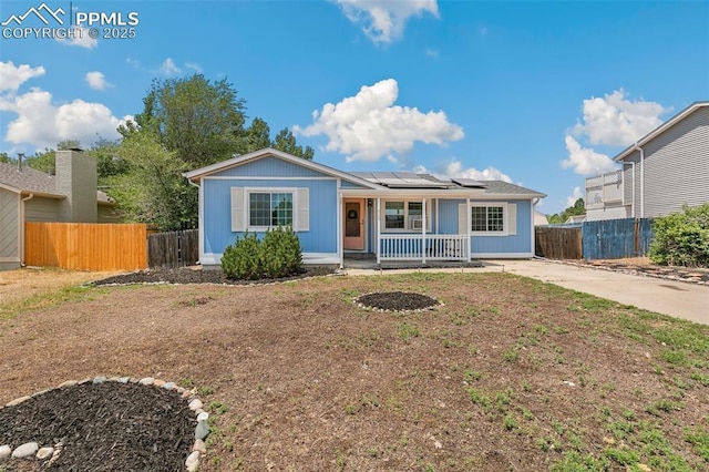 ranch-style house with covered porch and solar panels