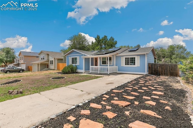 ranch-style house featuring a porch and solar panels