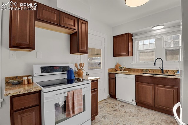 kitchen with sink, white appliances, and light stone counters