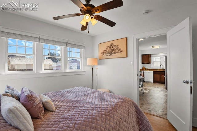 bedroom with ceiling fan, light hardwood / wood-style floors, and sink