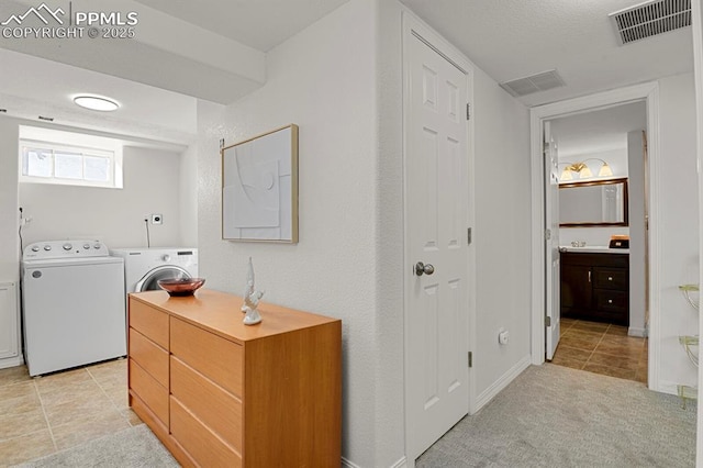 laundry room with washer and dryer and light colored carpet