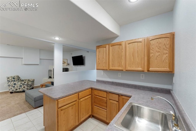 kitchen featuring kitchen peninsula, light tile patterned floors, and sink