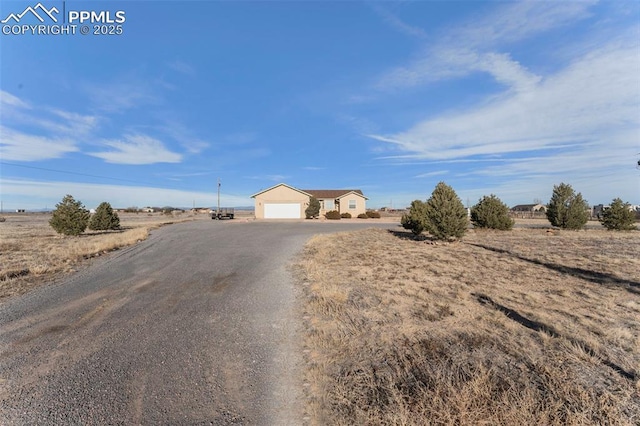 view of front facade featuring a rural view and a garage