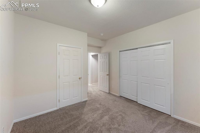 unfurnished bedroom featuring light colored carpet and a closet