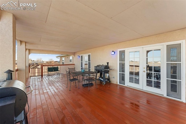 wooden terrace with a grill and french doors