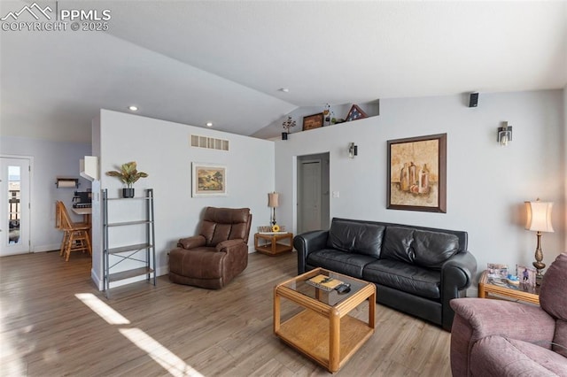 living room featuring light hardwood / wood-style floors and lofted ceiling