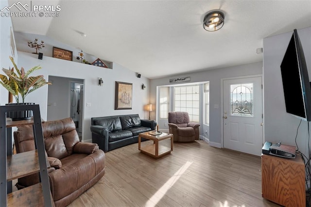 living room featuring light hardwood / wood-style flooring and lofted ceiling