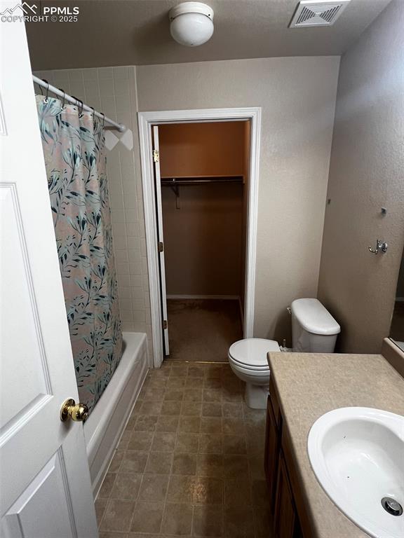 full bathroom with shower / bath combination with curtain, vanity, and toilet