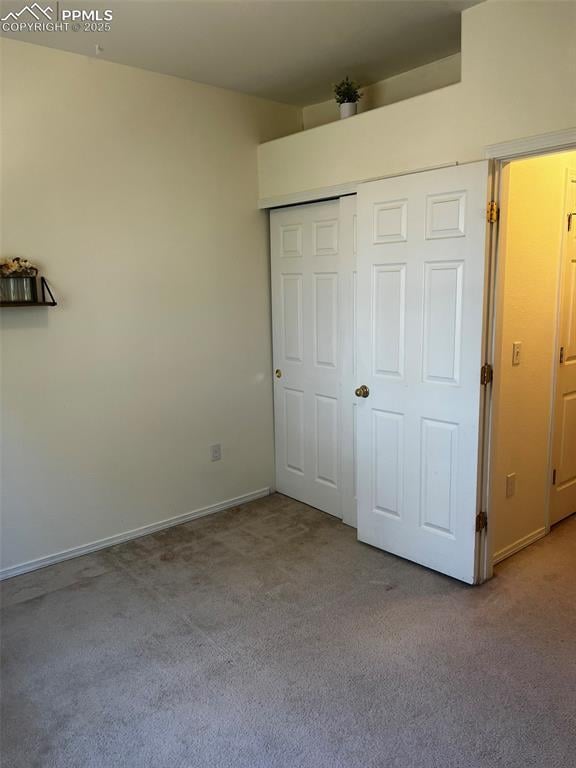 unfurnished bedroom with light carpet and a closet