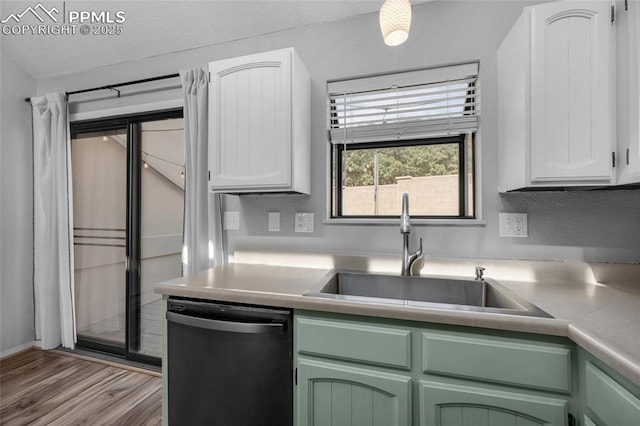 kitchen featuring green cabinets, white cabinetry, dishwasher, and sink