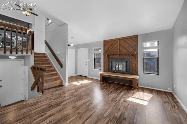 unfurnished living room featuring a fireplace, hardwood / wood-style flooring, and ceiling fan