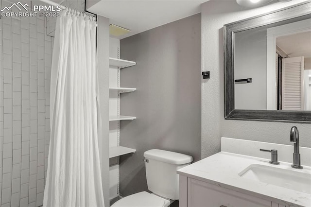 bathroom with walk in shower, vanity, and toilet