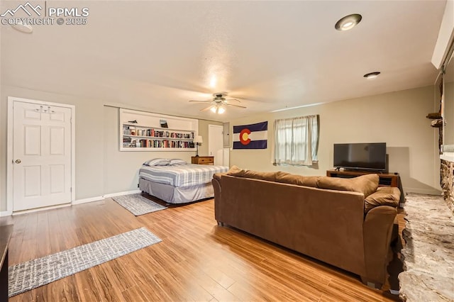 living room featuring ceiling fan and light hardwood / wood-style floors