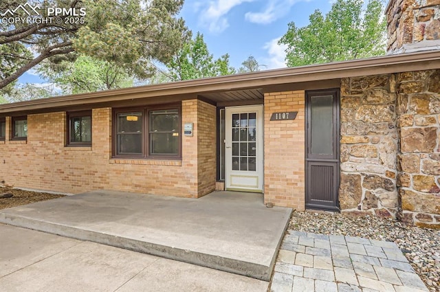 view of exterior entry with a patio area