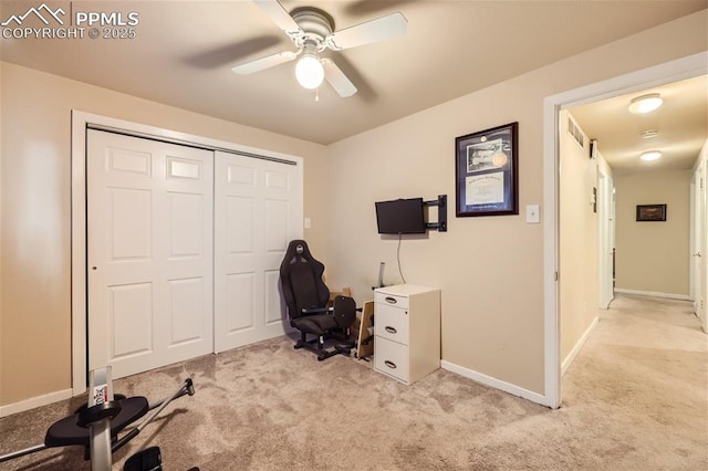 carpeted office space featuring ceiling fan