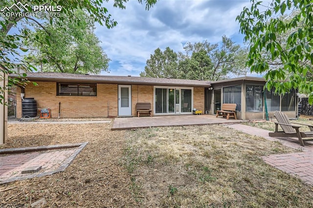 rear view of property featuring a sunroom and a patio