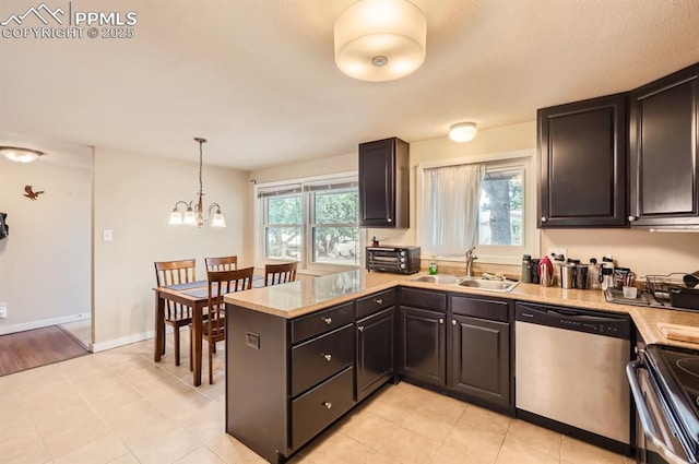 kitchen featuring decorative light fixtures, a wealth of natural light, sink, and appliances with stainless steel finishes