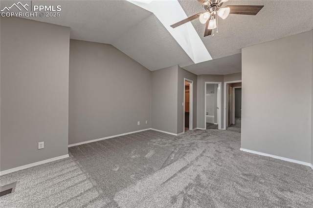 bonus room with lofted ceiling with skylight, carpet, a textured ceiling, and ceiling fan