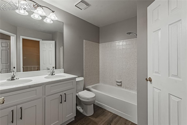 full bathroom with toilet, vanity, tiled shower / bath combo, and hardwood / wood-style flooring