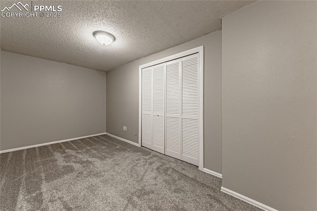 unfurnished bedroom featuring a textured ceiling, carpet floors, and a closet