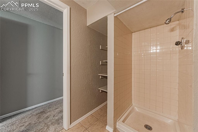 bathroom featuring a tile shower, a textured ceiling, and tile patterned floors