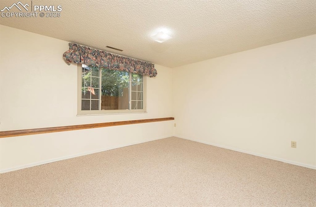 spare room with carpet and a textured ceiling