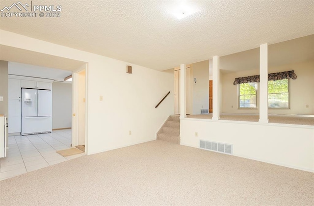 carpeted empty room with a textured ceiling