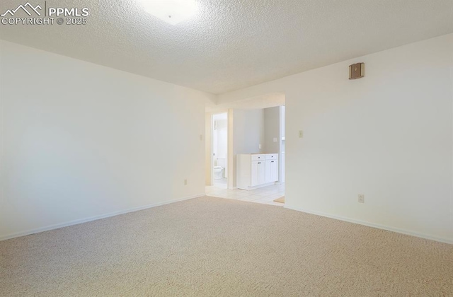 carpeted empty room featuring a textured ceiling