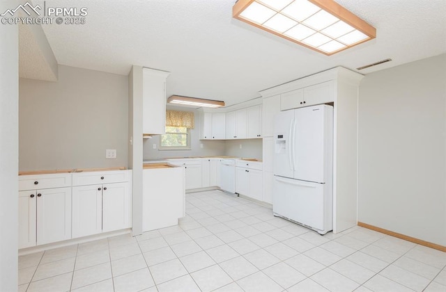 kitchen featuring white cabinets and white fridge with ice dispenser