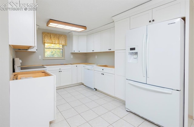 kitchen featuring light tile patterned floors, white cabinets, and white appliances