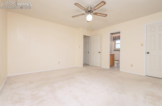 unfurnished bedroom with a textured ceiling, ceiling fan, light colored carpet, and ensuite bathroom