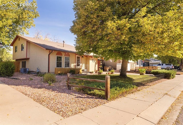 view of front of property featuring a front lawn and cooling unit